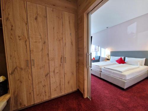 two beds in a room with wooden walls at Mosers Blume Relax & Genuss Hotel in Haslach im Kinzigtal