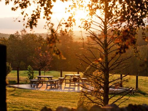 a picnic area with picnic tables in a field at Two The Old Stables in Knitsley