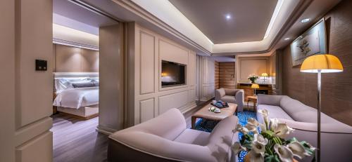a hotel room with a bedroom and a bed at Elegant International Hotel Shanghai - Bund Sichuan Road North Metro Station Branch in Shanghai