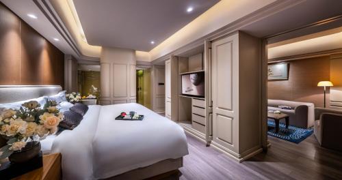 a bedroom with a large white bed and a living room at Elegant International Hotel Shanghai - Bund Sichuan Road North Metro Station Branch in Shanghai