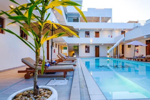a pool with a palm tree in a hotel at YU Resort in Msambweni