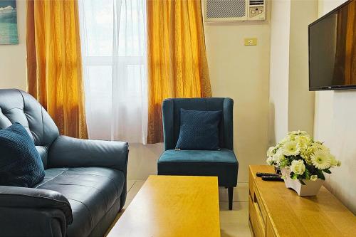 a living room with a couch and a chair at Gilmore Tower Suites By SMS Hospitality in Quezon City
