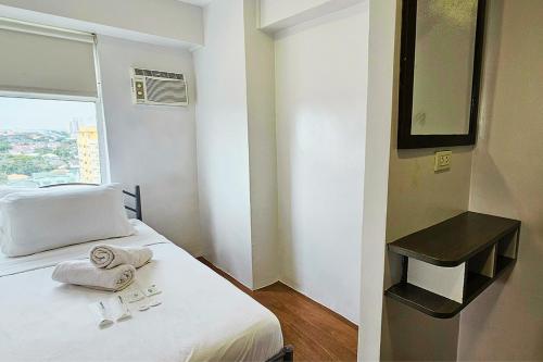 a hotel room with a bed with towels on it at Gilmore Tower Suites By SMS Hospitality in Quezon City
