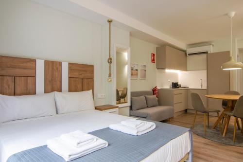 una camera da letto con un letto con due asciugamani sopra di VLC HOST - Reino a Valencia