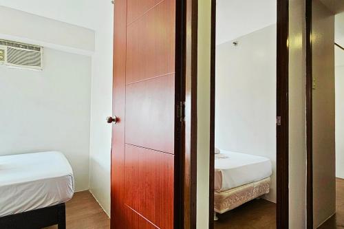 a room with a door and a bedroom with a bed at Gilmore Tower Suites By SMS Hospitality in Quezon City