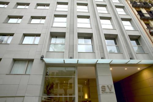 a tall white building with a sign on it at Suites Viena Plaza de España in Madrid