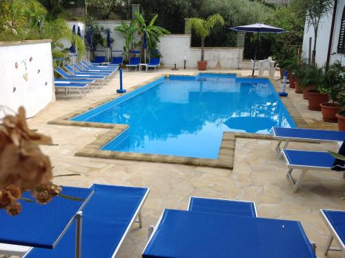 a large pool with blue chairs and tables at Villafiorita in Gioiosa Marea