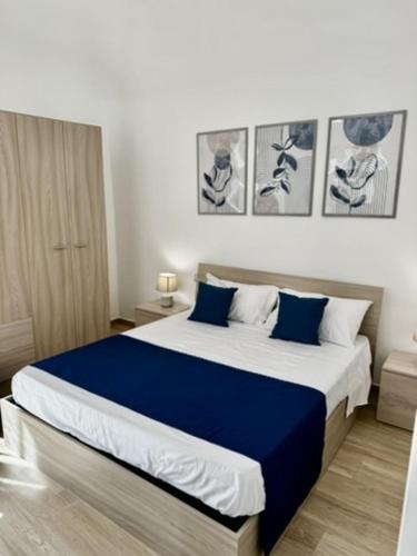 a bedroom with a large bed with blue sheets at Terrasini Center Apartments By Dimora Hub in Terrasini