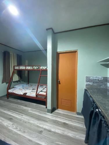 a room with two bunk beds and a door at Frogman inn in Puerto Princesa City