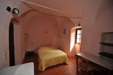 une chambre avec un lit et une fenêtre dans une pièce dans l'établissement Couvent de Tuani, à Costa