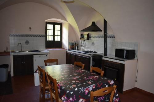 une cuisine avec une table et des chaises ainsi qu'une cuisine avec une arche dans l'établissement Couvent de Tuani, à Costa