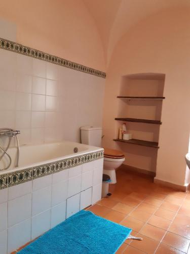 La salle de bains est pourvue d'une baignoire, de toilettes et d'un tapis bleu. dans l'établissement Couvent de Tuani, à Costa