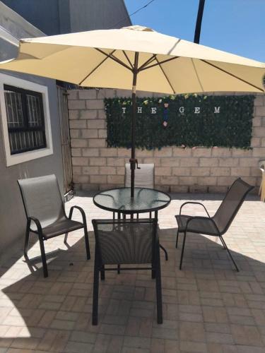 a table and two chairs and an umbrella on a patio at The Gem Suites & Spa in Parow