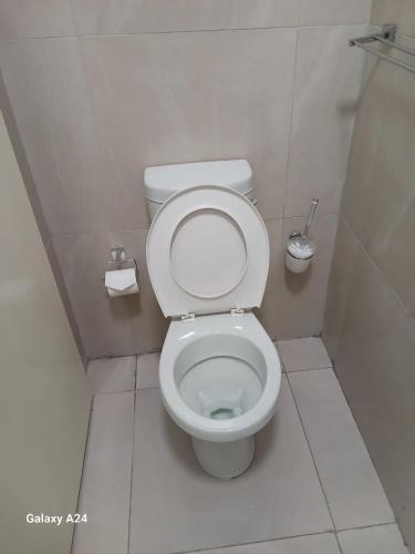 a bathroom with a toilet with the seat up at The Gem Suites & Spa in Parow