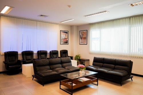 a living room with a couch and black chairs at Andakira Hotel - SHA Extra Plus in Patong Beach