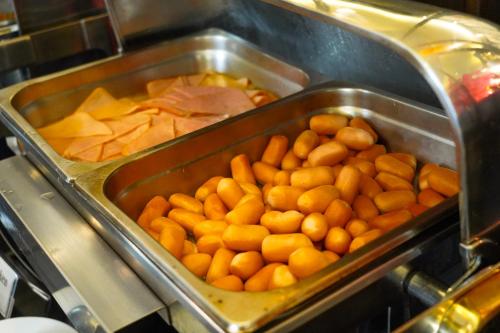 a tray of oranges and other food in a stove at Andakira Hotel - SHA Extra Plus in Patong Beach