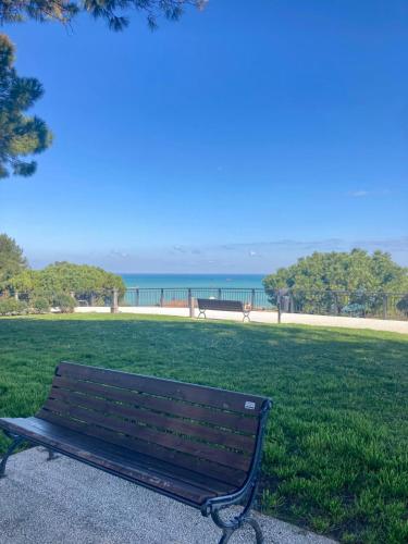a bench in a park with the ocean in the background at B&B Residenza Leonardo in Falconara Marittima