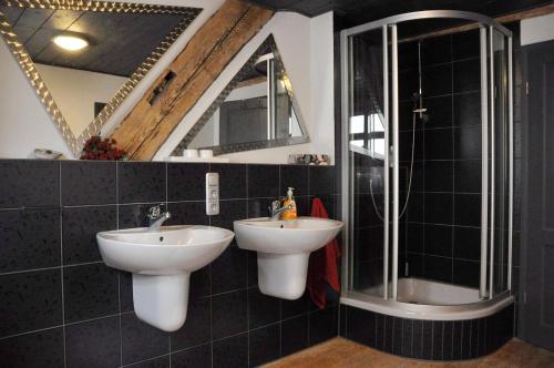 a bathroom with two sinks and a shower at Ferienwohnung am Wasserschloss in Schnabelwaid