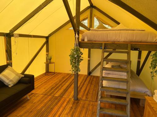 纽波特Usk View Glamping Caerleon的帐篷内带高架床的房间