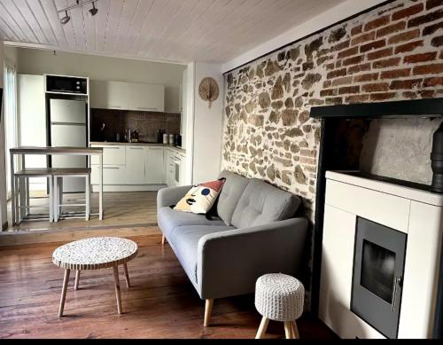 ラ・ロッシュ・シュル・ヨンにあるMaison Centre villeのソファとレンガの壁のあるリビングルーム