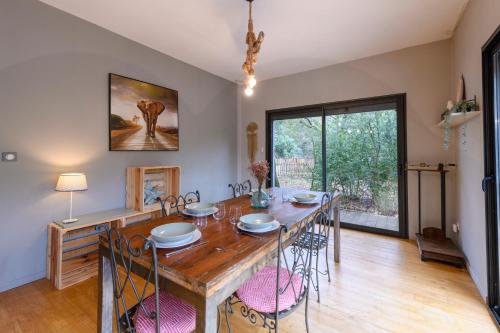 a dining room with a large wooden table and chairs at Chemin de Ronze - Maison au calme avec piscine in Labastide-de-Virac