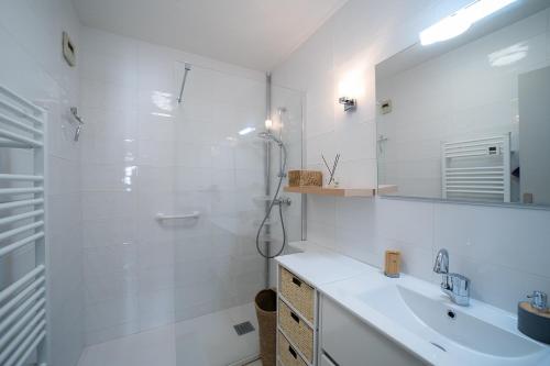 une salle de bain blanche avec une douche et un lavabo dans l'établissement Le Canigou - Vue montagne proche Perpignan, à Amélie-les-Bains-Palalda