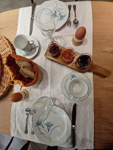 a table with plates and glasses on a table at Mas de la Borie -Chambre d'hôtes in Joannas