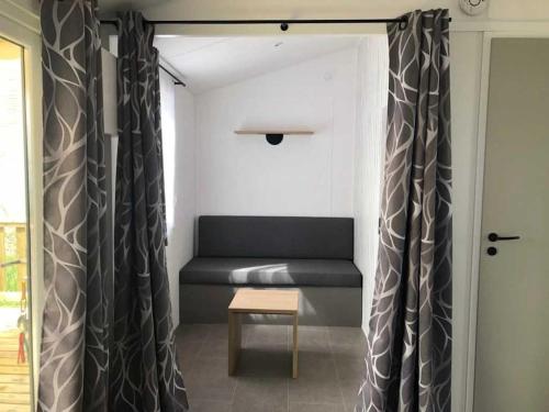 a living room with a couch and a table at Camping 3 étoiles - Piscine - ccaihff in Saint-Georges-de-Didonne