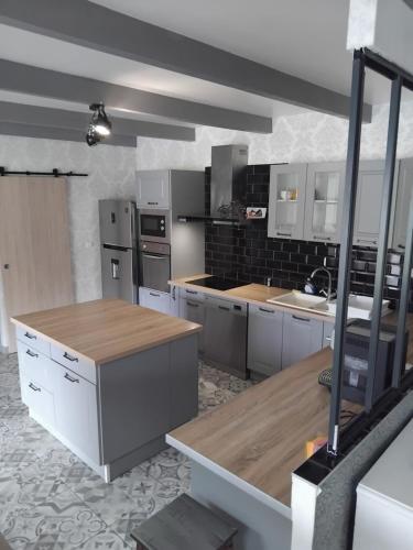 a large kitchen with white cabinets and wooden counter tops at Villas Paradis in Saint-Paul-lès-Dax