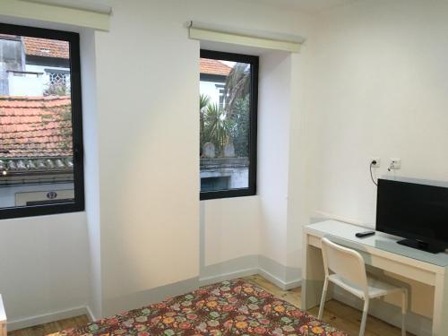 a room with a desk with a computer and a window at Casa da Praça - O Seu Refúgio no Coração Histórico de Aveiro in Aveiro