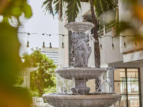 a fountain in front of a building at Bansuay Phranangklao Apartment&Hotel in Ban Sai Ma
