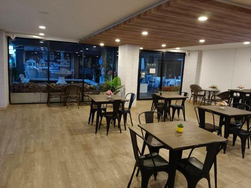 a restaurant with tables and chairs in a room at Bansuay Phranangklao Apartment&Hotel in Ban Sai Ma