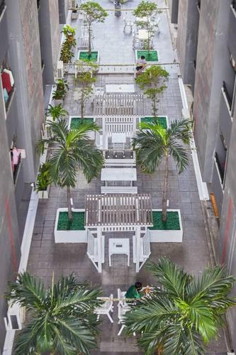 an overhead view of a courtyard with benches and palm trees at Bansuay Phranangklao Apartment&Hotel in Ban Sai Ma