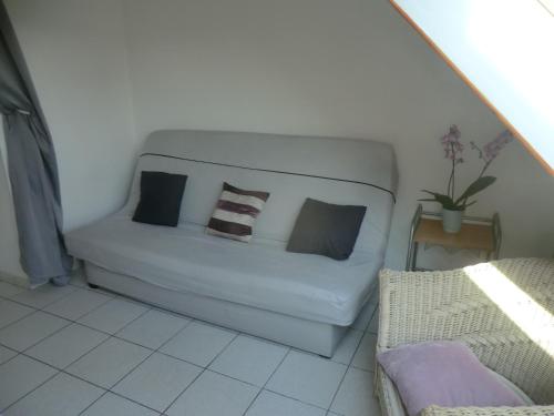 - un canapé blanc avec des oreillers dans l'établissement Douarnenez tréboul près des plages, à Douarnenez