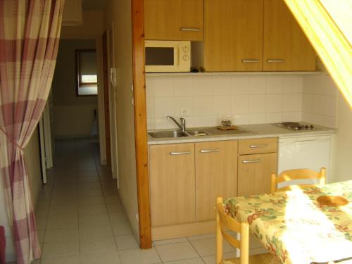 La cuisine est équipée d'une table, d'un évier et d'un four micro-ondes. dans l'établissement Douarnenez tréboul près des plages, à Douarnenez