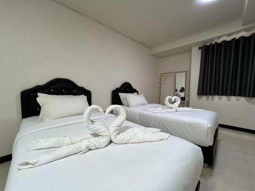 two swans made to look like swans sitting on two beds at Bansuay Phranangklao Apartment&Hotel in Ban Sai Ma