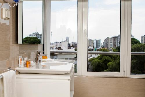een badkamer met een wastafel en een groot raam bij Montebelo Girassol Maputo Hotel in Maputo