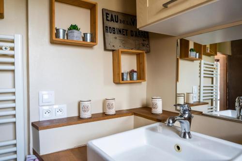 une salle de bain avec un lavabo et un miroir dans l'établissement Appartement pour 2, Place Saint-Sauveur, à Caen
