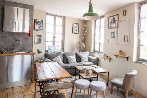 un salon avec un canapé et une table dans l'établissement Appartement pour 2, Place Saint-Sauveur, à Caen