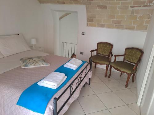 a bedroom with a bed and two chairs at DOMUS CIVITELLA - Chieti in Chieti