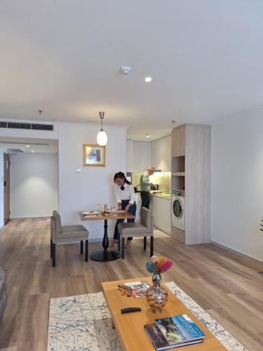 a man and a woman sitting at a table in a living room at Residence on Langley Park in Perth