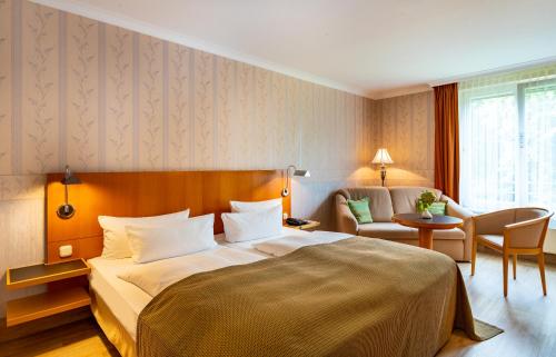 a hotel room with a bed and a table and chairs at Parkhotel Görlitz in Görlitz