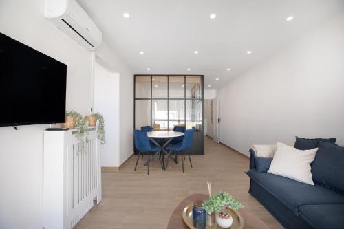 a living room with a blue couch and a table at Saint Honorât, Juan Les Pins Antibes Terrasse in Juan-les-Pins