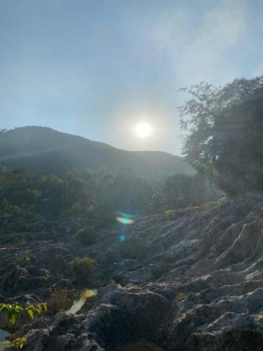a view of a mountain with the sun in the background at Hồ Đá Cổ Thiên Long Resort Hòa Bình in Hòa Bình