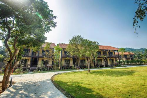 a large building with a park in front of it at Hồ Đá Cổ Thiên Long Resort Hòa Bình in Hòa Bình