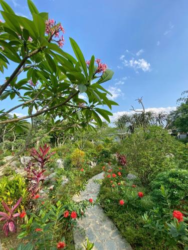 a garden with flowers and plants on a hill at Hồ Đá Cổ Thiên Long Resort Hòa Bình in Hòa Bình