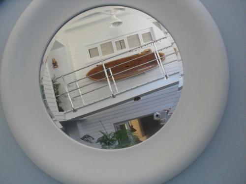 a mirror with a reflection of a surfboard in it at A Boat House in Simonʼs Town