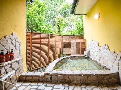 a hot tub in the corner of a house at Gasthof Ami in Nikko