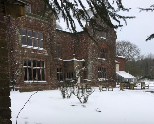 a large brick building with snow on the ground at Uplands Guest House in Ledbury