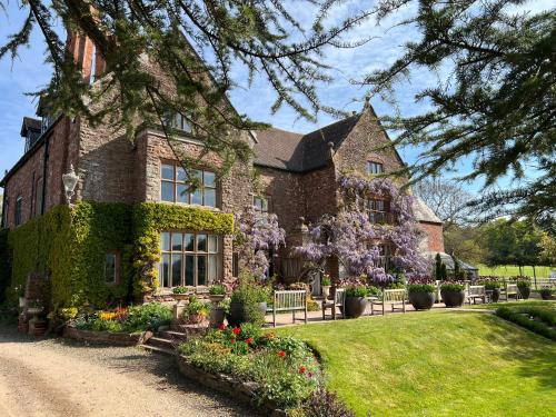 a brick house with flowers in front of it at Uplands Guest House in Ledbury